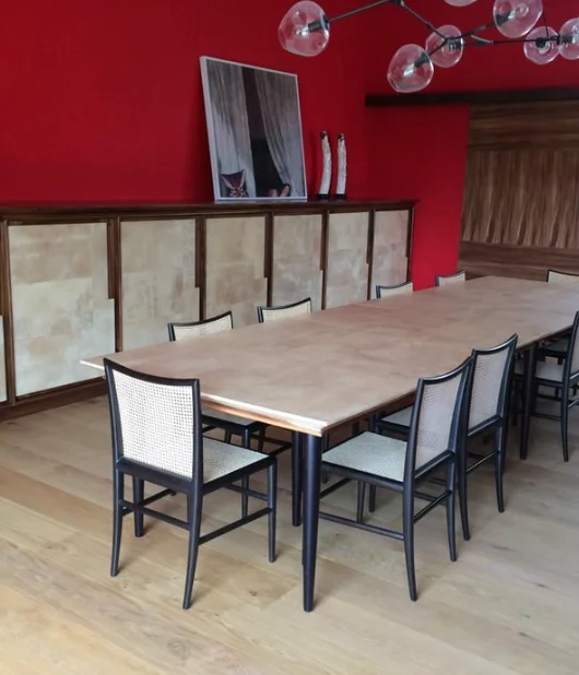 Comedor de lujo con mesa y credenza en pergamino perla y sillas de rejilla