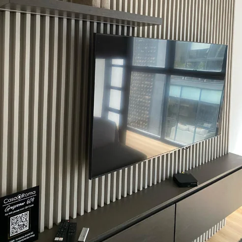 Consola de TV flotante en caoba sobre lambrín de madera