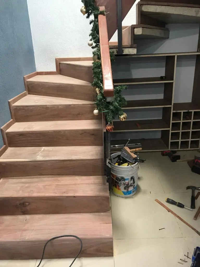 Escalera de madera con cava y repisas bajo huellas