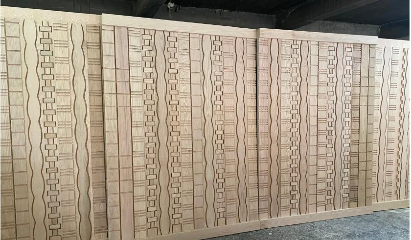 Biombo divisor de madera clara con tallado CNC geométrico, solución arquitectónica para espacios