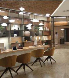 Recepción de hotel con estantería iluminada y techo de listones de madera